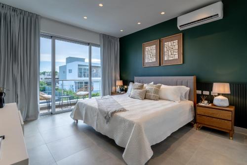a bedroom with a large bed and a green wall at Caribbean Paradise Villa in Playa Nueva Romana in Boca del Soco