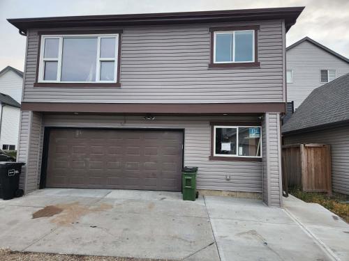 a house with a garage door and a driveway at Modern Family Home with guest heat garage, Pet-Friendly!- NO BASEMENT in Edmonton