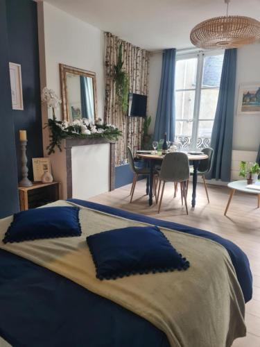 - une chambre avec un lit bleu et une salle à manger dans l'établissement Studio 4 personnes aux pieds du château de Blois avec expérience de dormir sous les aurores boréales, à Blois