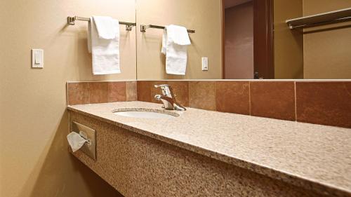 y baño con lavabo, espejo y toallas. en Best Western Diamond Inn, en Three Hills