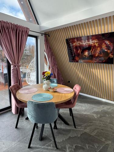 a dining room with a wooden table and chairs at Cabana A Frame In Jomp in Gîrda de Sus