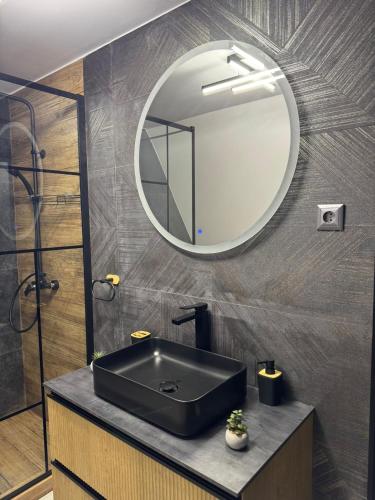 a bathroom with a black sink and a mirror at Cabana A Frame In Jomp in Gîrda de Sus