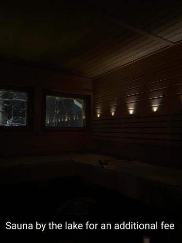a dark room with a tub and two windows at Room by Lake 10 minutes from Tampere centrum in Lempäälä