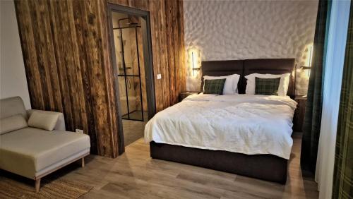 a bedroom with a bed and a chair and a mirror at Rădăcini in Câmpulung Moldovenesc