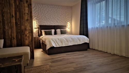a bedroom with a large bed and a large window at Rădăcini in Câmpulung Moldovenesc