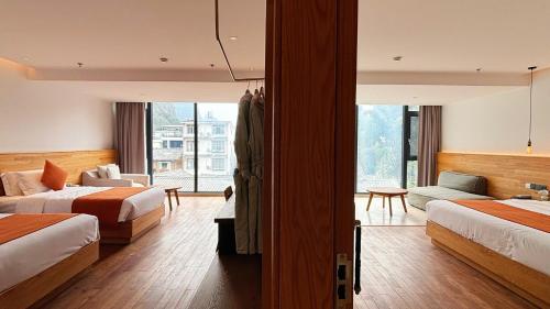 a hotel room with two beds and a couch at the Wild Luxury Holiday Inn in Xingping