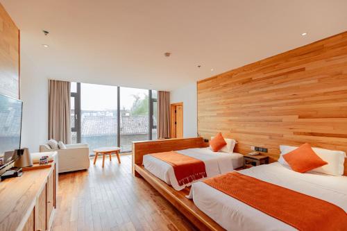 a hotel room with two beds and a television at the Wild Luxury Holiday Inn in Xingping