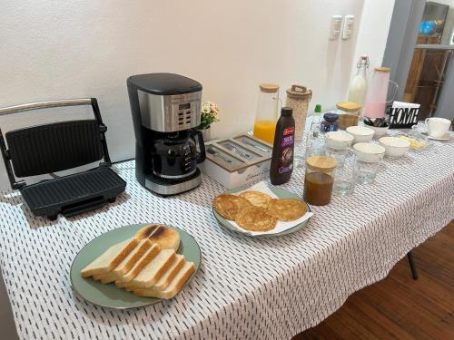 a table topped with bread and a coffee maker and a table with a coffee maker at Casona Italia B & B in Santiago