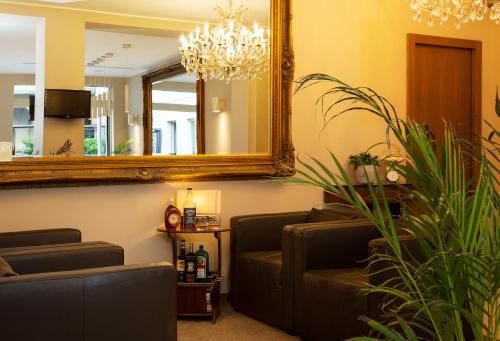 a waiting room with a mirror and a couch at La Castellana Loft Hotel in Bergamo