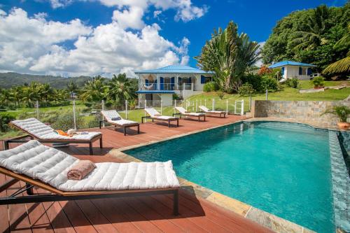 una piscina con sedie a sdraio e una casa di Villa M'Bay a Sainte-Marie