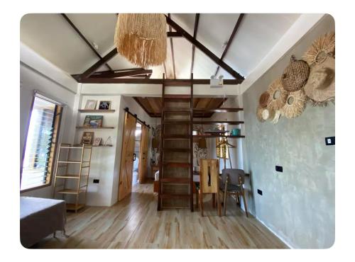 a living room with a staircase and a dining room at La Casa Sofia in Surigao