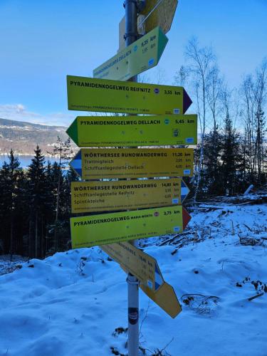 a street sign with several signs in the snow at "Casa Antonio" 3 Gehminuten Strandbad Sekirn, inkl Seezugang in Sekirn