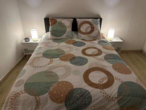 a bed with a comforter and pillows on it at Gîte Le Central - Port & Plage in Fécamp