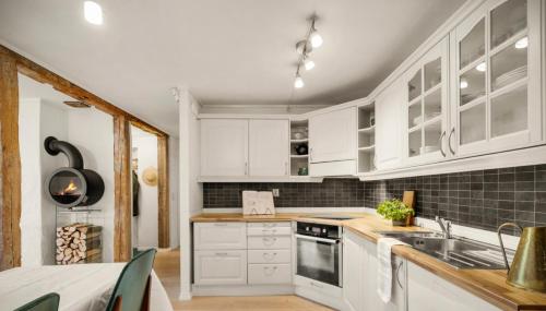 Una cocina con gabinetes blancos y un fregadero. en The old bakery in Sandviken, en Bergen