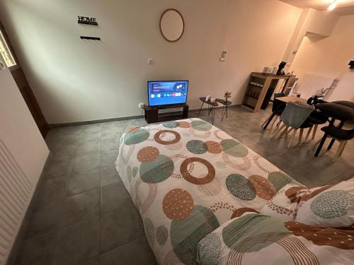 a living room with a bed and a flat screen tv at Gîte Le Central - Port & Plage in Fécamp