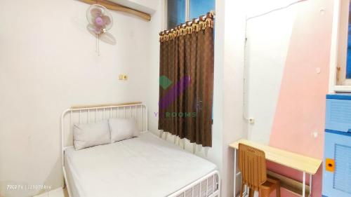 a small room with a bed and a window at New Jasmine Guest House by Yurooms in Karangtengah