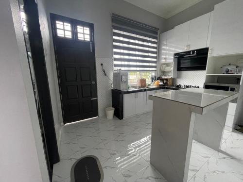 a kitchen with a black door and a kitchen counter at D Raihan Guest House in Ketereh
