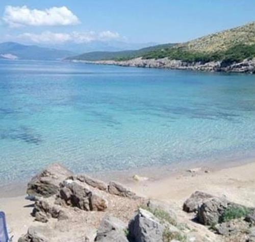 a beach with rocks and the blue water at Villa Symphony apartments Kotor Tivat in Kotor