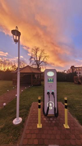 a pay phone sitting on a field next to a street light at Hotel Maxim Kwidzyn in Kwidzyn