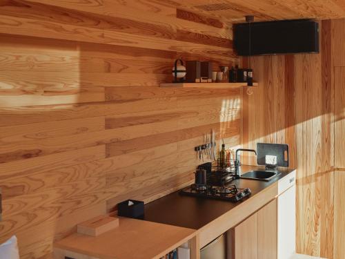 eine Küche mit Holzwänden und einer Arbeitsplatte in der Unterkunft allbeans KOCHI in Kami