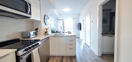 a kitchen with white cabinets and a stove top oven at 1 Bedroom condo with balcony Erb St Waterloo in Waterloo