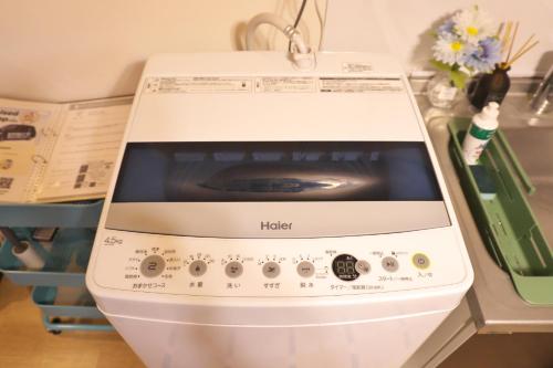 a microwave oven sitting on top of a counter at ZenAbode303 羽田空港電車8分 都心エリア電車12分 in Tokyo