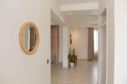 a hallway with white walls and a mirror on a wall at Kwetu Villas Musanze in Ruhengeri