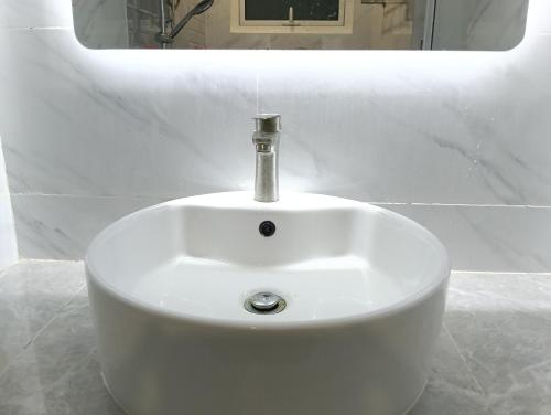 a white sink with a faucet in a bathroom at H62 Muar Home in Muar
