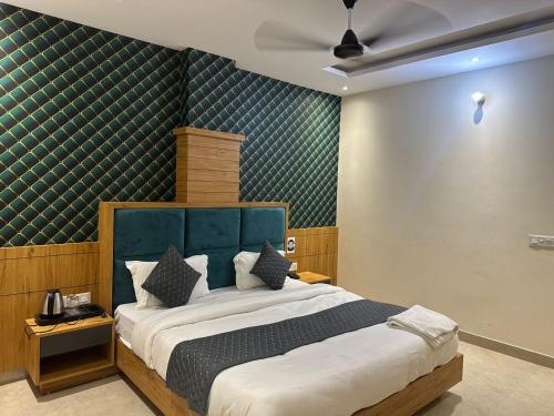 a bedroom with a large bed with a blue headboard at Taj Castle by iO Hotels in Amritsar