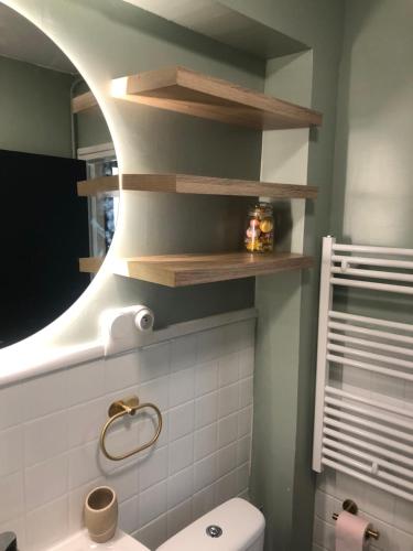 baño con aseo blanco y estanterías de madera en seagarden wissant, en Wissant