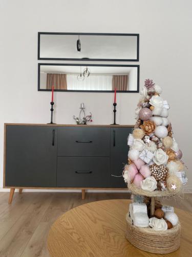 a room with a christmas tree in front of a dresser at Malina Residence Aparthotel in Cisnădie