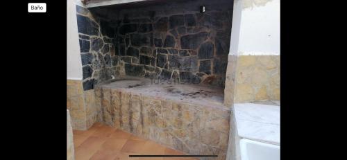 a stone fireplace in the corner of a room at Arena apartment in Faro de Cullera