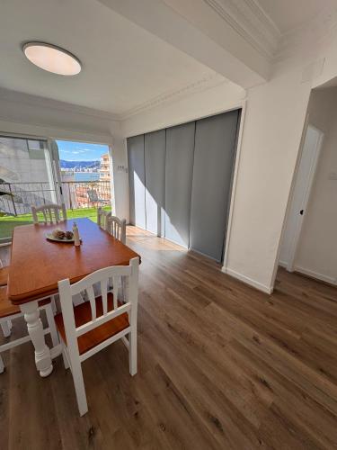 a dining room with a table and chairs and a large window at Arena apartment in Faro de Cullera