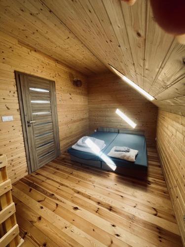 a room with a bed in a wooden room at Domki Wieleń in Wielen Zaobrzanski