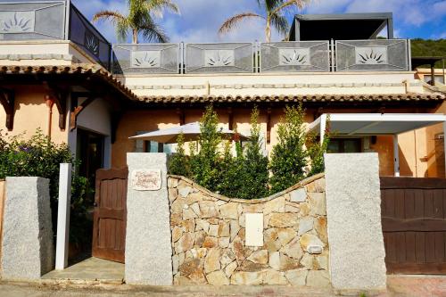 a house with a stone fence in front of it at Casa asfodelo in Chia