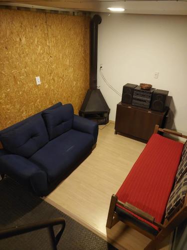 a living room with a blue couch and a stove at Sitio Paraopeba in São Joaquim de Bicas