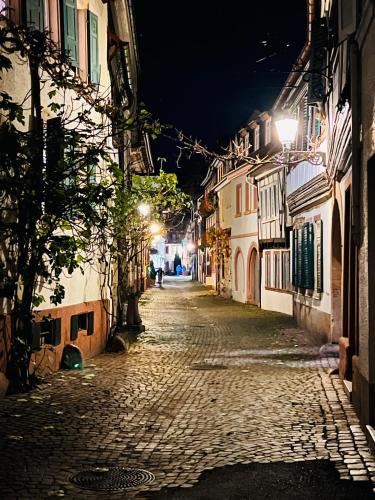 a cobblestone street at night with street lights at ARTvacanza Neustadt in Neustadt an der Weinstraße