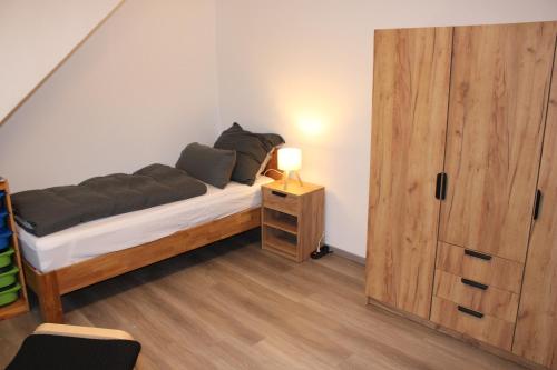 Un dormitorio con una cama y una puerta de madera. en FeWo Oberhausen-Styrum, en Oberhausen