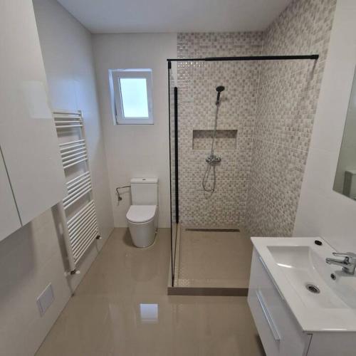 a bathroom with a shower and a toilet and a sink at myHome Residence in Nazna