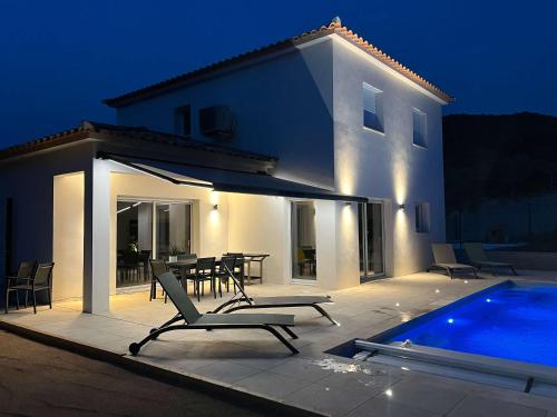 a villa with a swimming pool in front of a house at Casamea - Villa Familiale, Piscine, 15 min Ajaccio in Alata