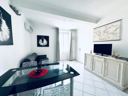 un salon avec une table en verre et une télévision dans l'établissement Grand appartement centre piéton Cannes, à Cannes