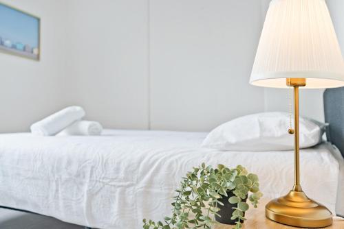 a lamp and a plant on a table next to a bed at Urban Stay Central Convenience on Broadway Ultimo in Sydney