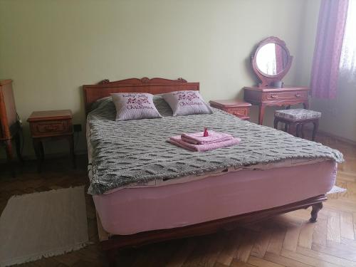 普热梅希尔Center Apartment的一间卧室配有一张带粉红色浴袍的床