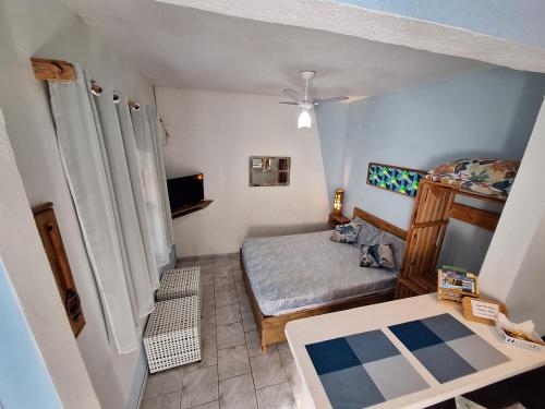 a small room with a bed and a table at Residencial Maresias Suites e Chalés in Maresias