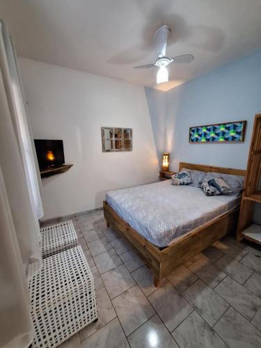 a bedroom with a bed and a ceiling fan at Residencial Maresias Suites e Chalés in Maresias