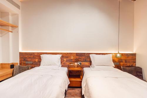 two beds sitting next to each other in a room at the Wild Luxury Holiday Inn in Xingping