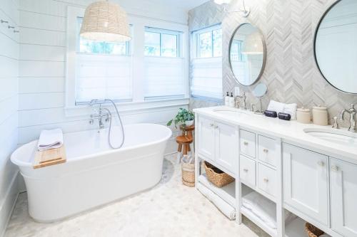 a white bathroom with a tub and a sink at Gulf Bridge by Stay on 30A- Pool, Bikes, Golf Cart in Inlet Beach