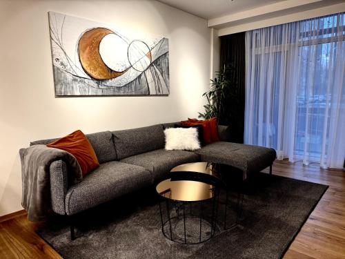 a living room with a couch and a table at Parko rezidencija apartments - SELF CHECK-IN in Panevėžys