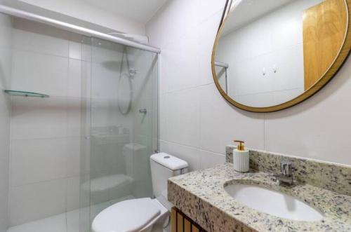 a bathroom with a sink and a toilet and a mirror at Casa Itacimitim Praia do Surf in Camacari