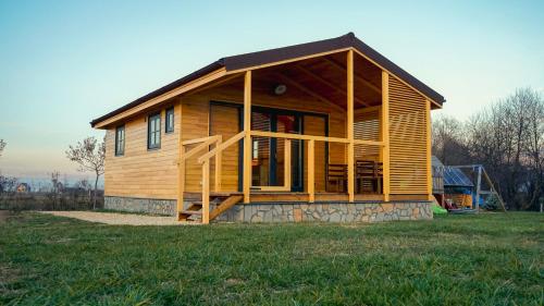 a small wooden house on a grass field at Atelier Recreation Village in Râşnov